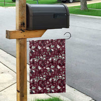 Wine red garden flag hanging from a wooden post with white poinsettias and birds