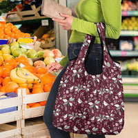 Wine red holiday tote bag with white botanical pattern and dual handles, carried on arm