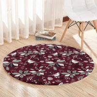 Wine red round rug with white festive bird, leaf, and star print