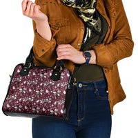 Wine red floral shoulder handbag with black handles, held close