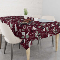 Wine red Christmas tablecloth draped on dining table, poinsettia and holly print