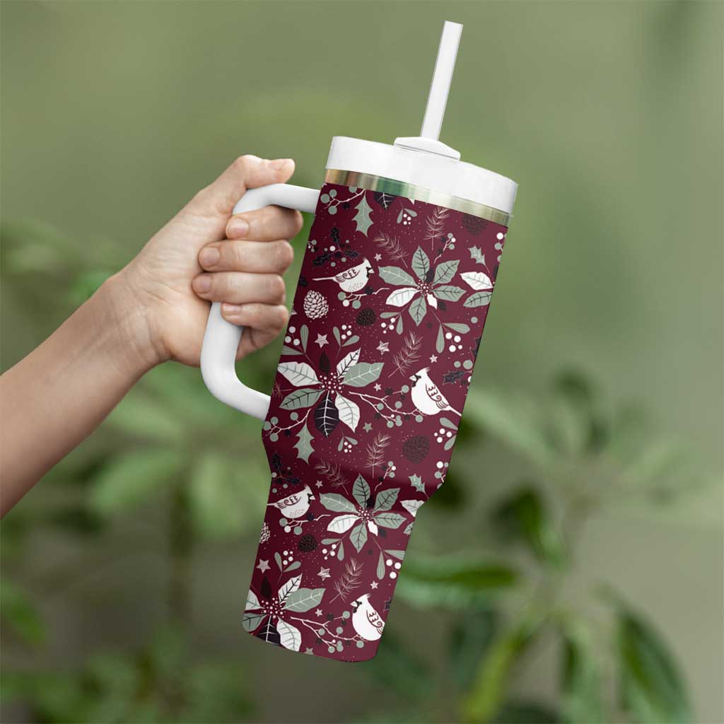 Wine red handled tumbler with clear straw and white holiday pattern, held in hand