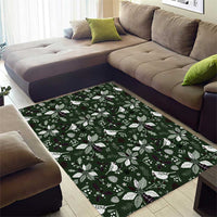 Rectangular green area rug lying flat with festive leaf and flower pattern in white and purple