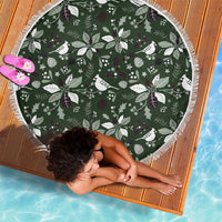Round green beach blanket with bird, pine and berry pattern and white fringe edging