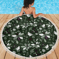 Round green Christmas beach blanket with white fringe edge and holly and bird motif