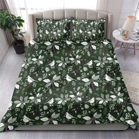 Green bedding set with matching pillowcases and Christmas leaf-and-bird pattern, bed view