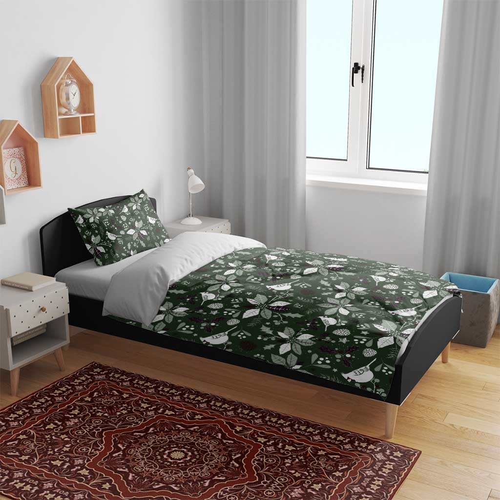 Green bedding set on bed with Christmas leaf-and-bird patterned duvet and pillow
