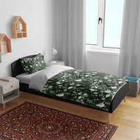 Green bedding set on bed with Christmas leaf-and-bird patterned duvet and pillow
