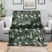 Green Christmas blanket with white bird and foliage pattern, laid out for viewing