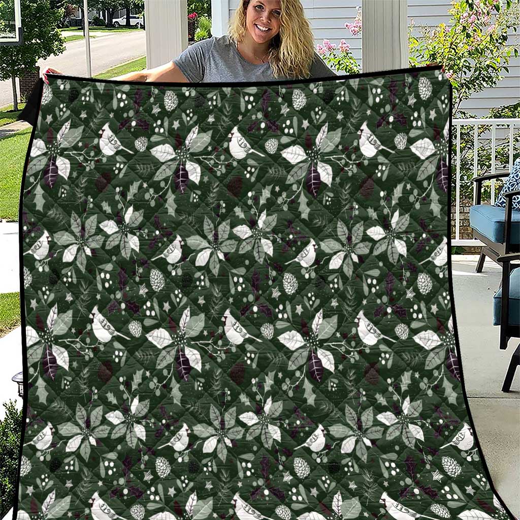 Green Christmas quilt with repeating white bow and leaf motifs, stitched border