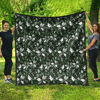 Green Christmas quilt blanket with white bow-and-leaf pattern and dark edge trim