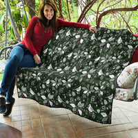 Green Christmas quilt with white bow-and-leaf motifs, folded edge and border trim