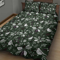 Green quilt bed set on bed with two pillows, white leaf and bird motifs