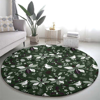 Green round carpet featuring white birds, pinecones, and leaf motifs