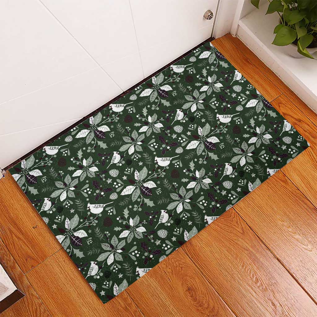 Green rubber Christmas doormat with white leaf and bird pattern, angled on floor
