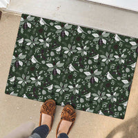 Green rubber Christmas doormat with white leaf and bird pattern, on entry floor