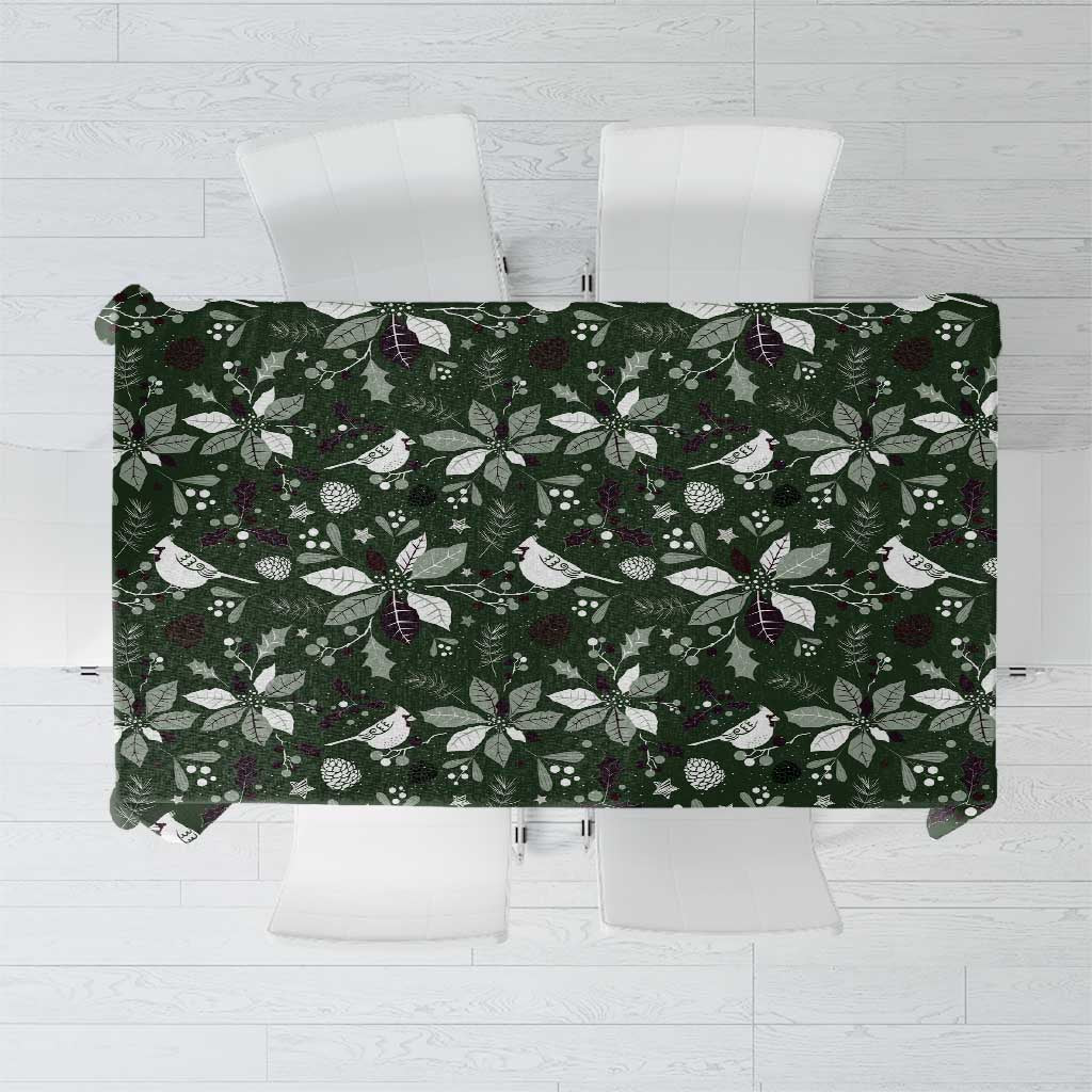 Green Christmas tablecloth with white birds, leaves, and pinecones pattern.