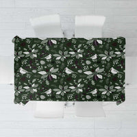 Green Christmas tablecloth with white birds, leaves, and pinecones pattern.
