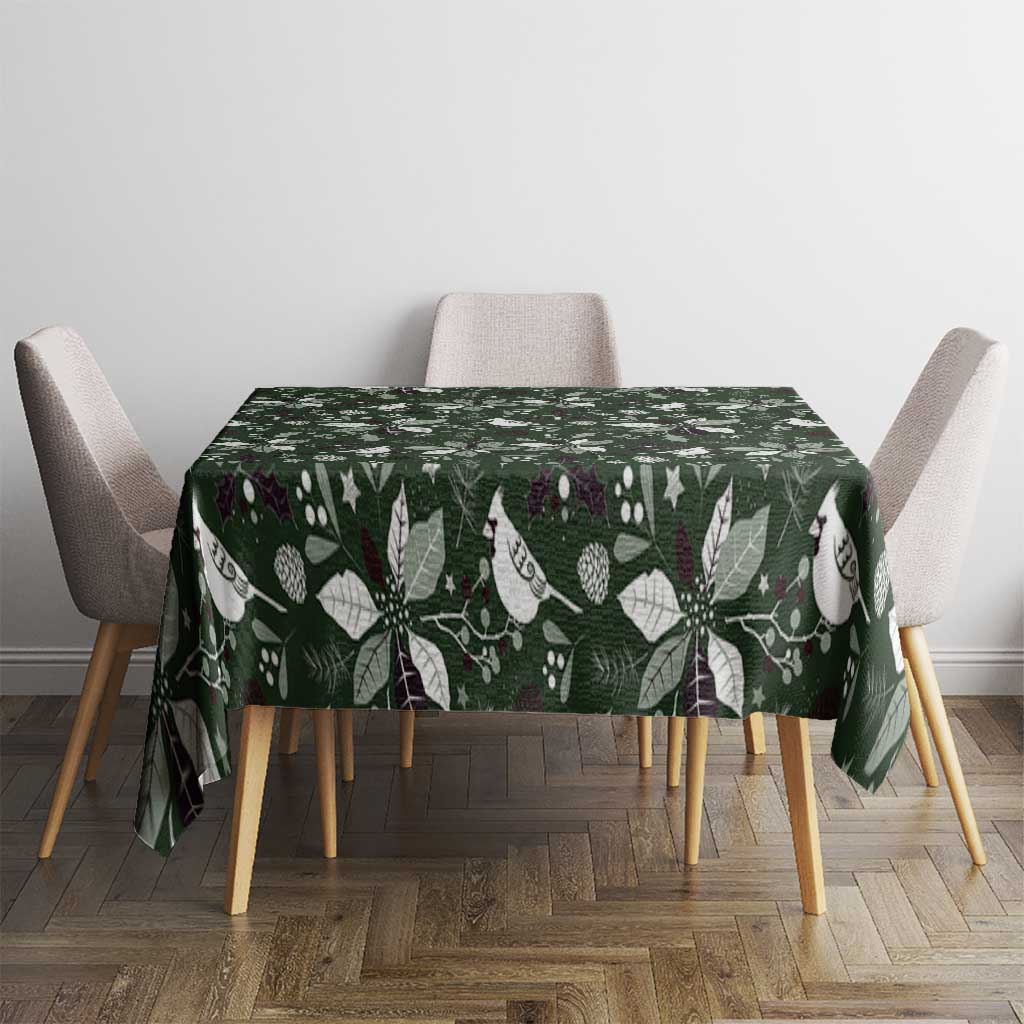 Green Christmas tablecloth on table with white bird and leaf pattern.
