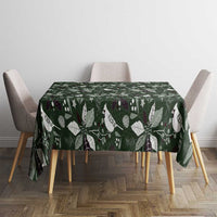 Green Christmas tablecloth on table with white bird and leaf pattern.
