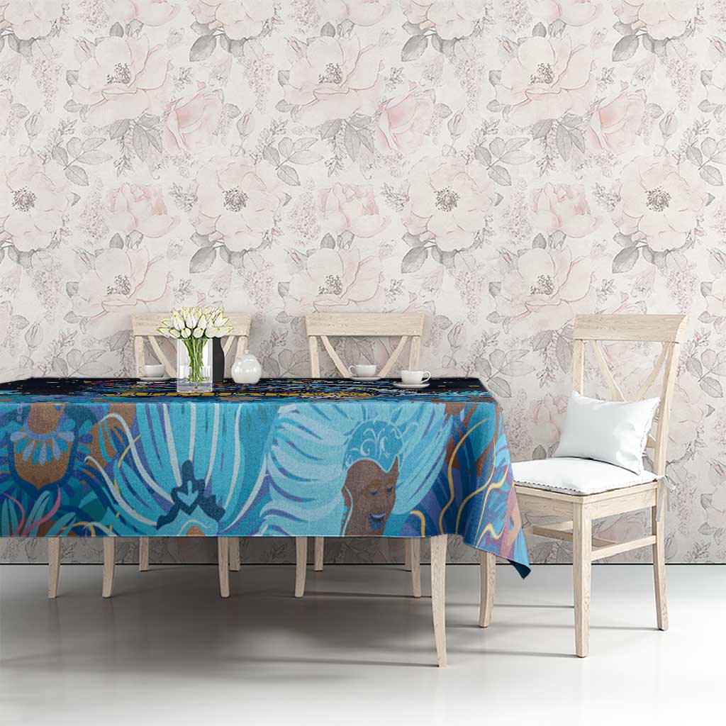 Blue tablecloth with Junkanoo mask artwork on a dining table