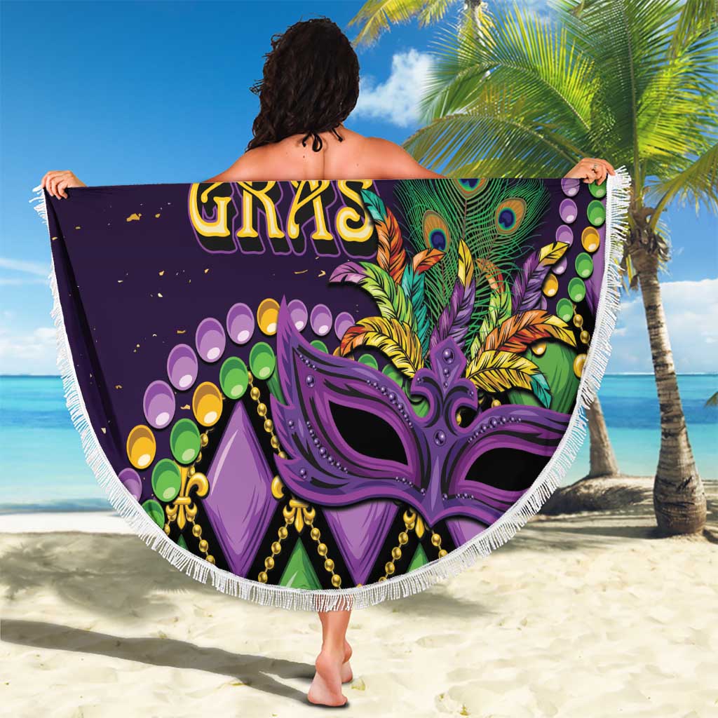 Round purple beach blanket with tassel fringe showing mardi gras lettering and fleur-de-lis
