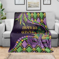 Mardi Gras throw blanket draped on a sofa, purple green mask and fleur-de-lis design