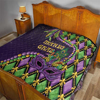 Purple Mardi Gras quilt on a bed with diamond pattern, green accents, and purple mask