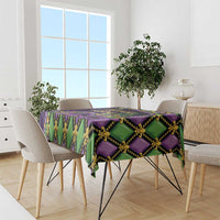 Mardi Gras tablecloth draped on dining table, purple green and gold fleur-de-lis mask design