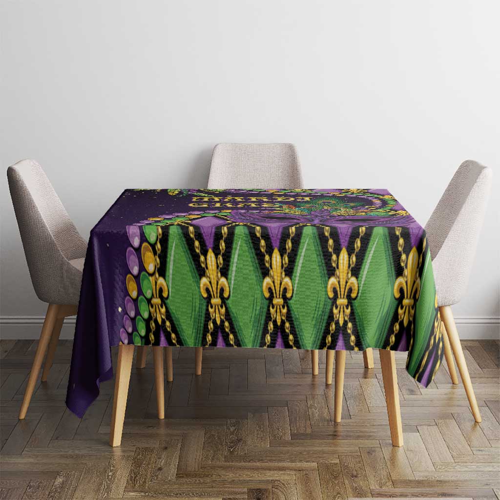 Mardi Gras tablecloth on square table, purple green and gold fleur-de-lis mask motif