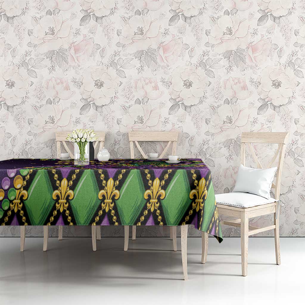 Mardi Gras tablecloth on long table, purple green and gold fleur-de-lis mask print
