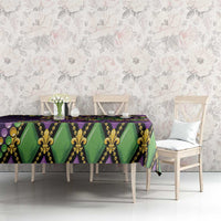Mardi Gras tablecloth on long table, purple green and gold fleur-de-lis mask print