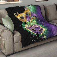 Quilt draped on gray sofa, black fabric with purple and green Mardi Gras feather art