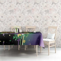 Purple Mardi Gras tablecloth with mask, feathers, and gold dot accents across top
