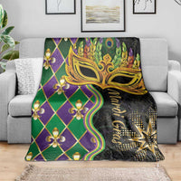 Mardi Gras blanket draped over sofa, gold mask center with green purple fleur-de-lis diamonds