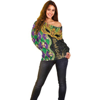 Women’s off-shoulder sweater with vibrant green, purple, and gold mask artwork