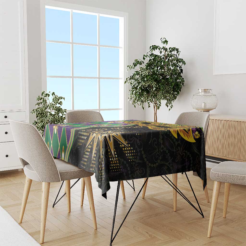 Mardi Gras tablecloth draped on table, black base with gold and green Mardi Gras graphics