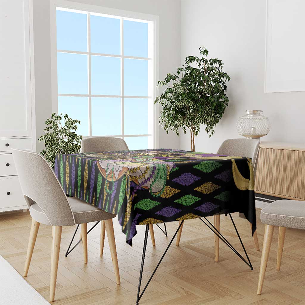 Mardi Gras tablecloth draped on dining table, black purple green vertical stripe pattern
