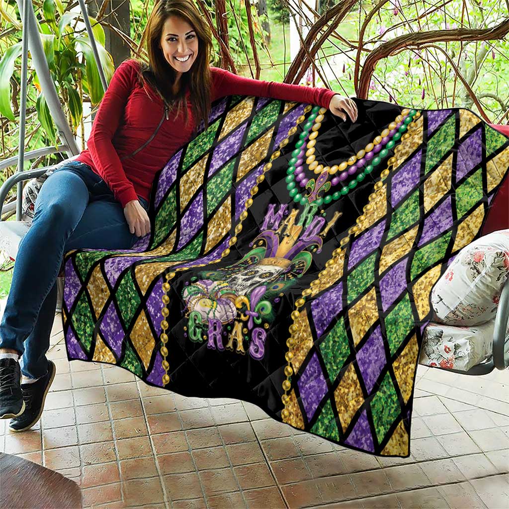 Mardi Gras quilt blanket laid out with purple diamond sides and colorful bead necklace trim
