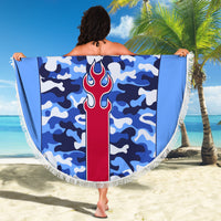 Blue camouflage round beach blanket with fringe border and central flame emblem graphic.