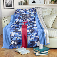 Blue camo football blanket with Samurai Blue text and red torch emblem, draped on sofa