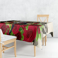 Tablecloth draped on dining table with red roses and multicolor leaf pattern