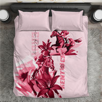 Pink bedding set with red horse racing graphic and floral lilies, two matching pillows