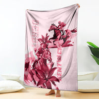 Pink blanket showing a maroon galloping horse and bold lily blossoms, draped