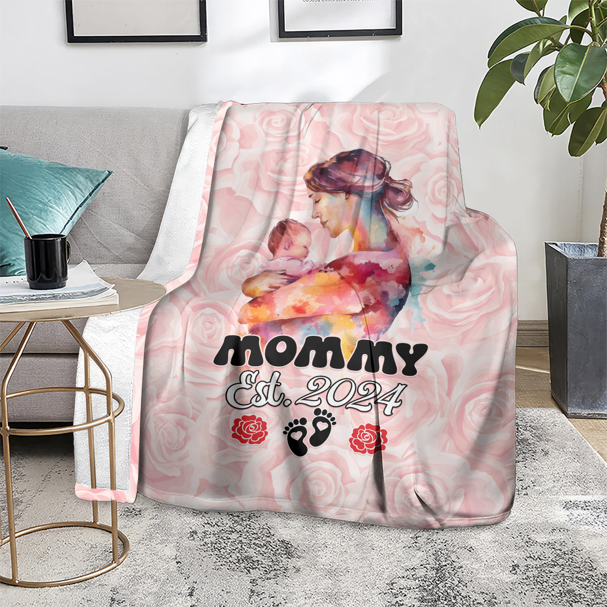 Pink mother’s day blanket folded on couch, Mom Est. 2024 and rose-paw graphics