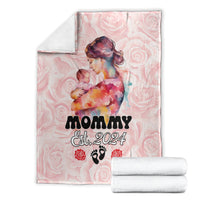 Pink mother’s day blanket with Mom Est. 2024 artwork, shown with folded white towels
