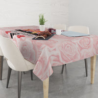 Pink rose-pattern tablecloth on dining table with candle and drink items