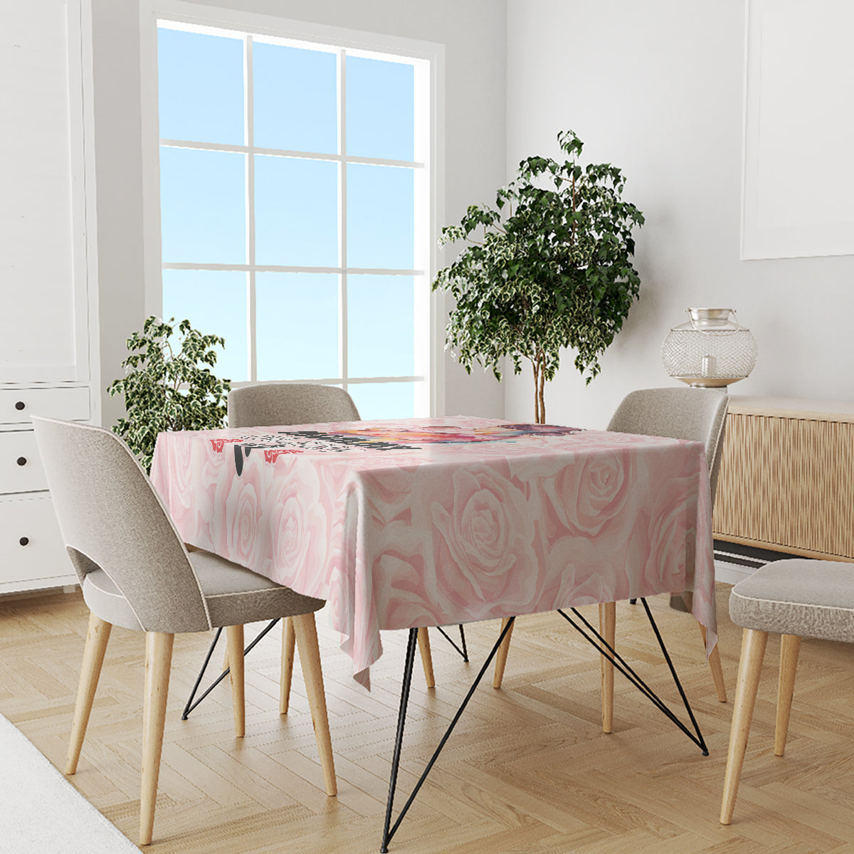 Pink rose-pattern tablecloth on dining table with chairs near the window