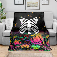Black Halloween skeleton blanket draped over gray couch, trick-or-treat pumpkin graphics
