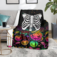 Black skeleton blanket on light rug with trick-or-treat pumpkin faces in bright colors